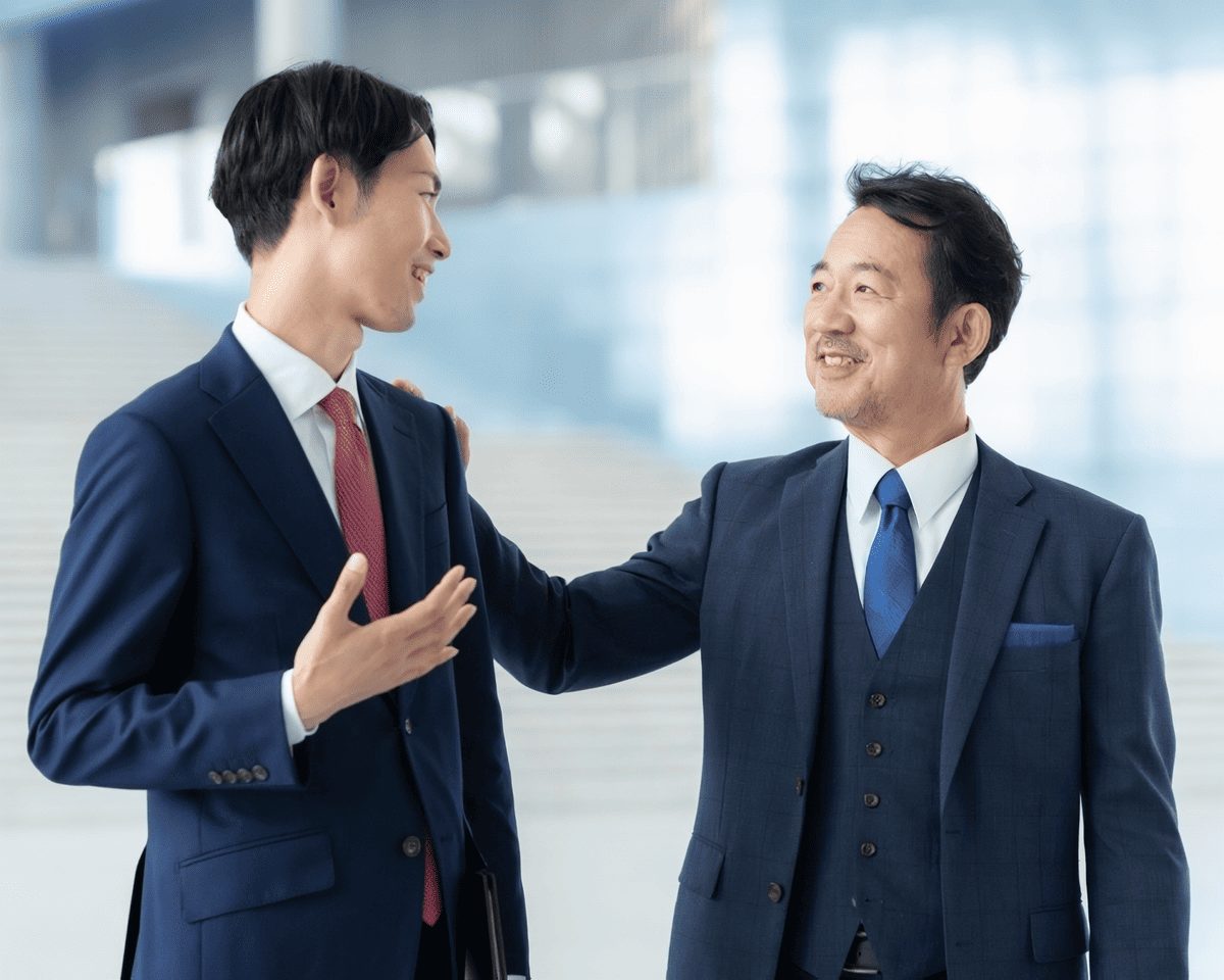 男性2人がスーツで会話をしている