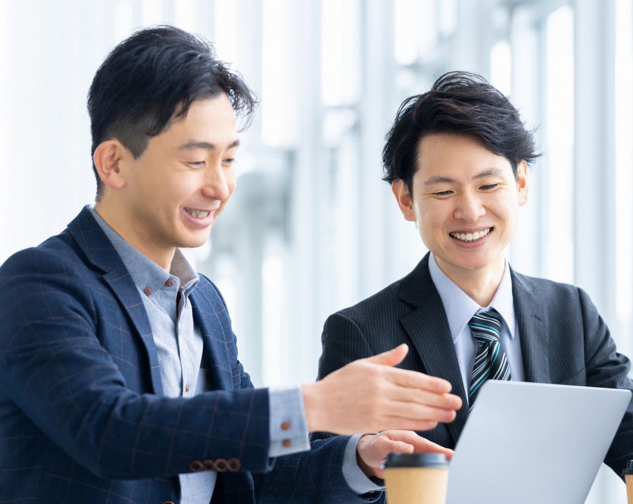 スーツを着た男性二人が話し合っている